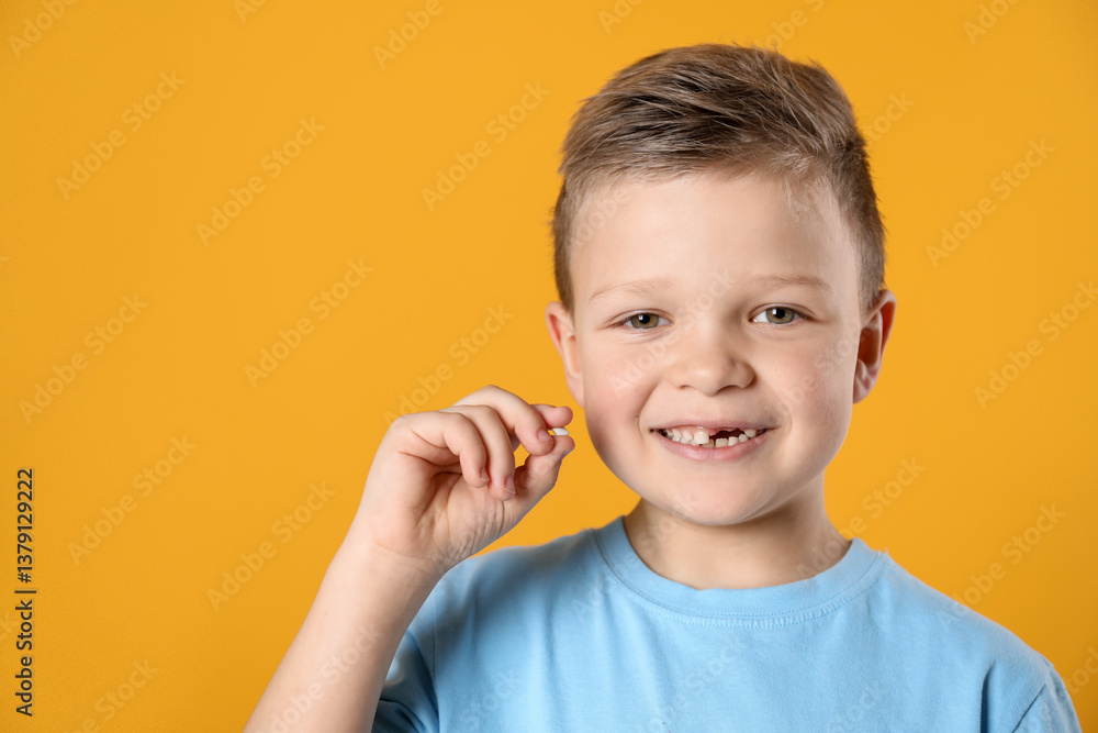 Cute little boy with missing tooth on orange background, space for text. Waiting for tooth fairy Cute little boy with missing tooth on orange background, space for text. Waiting for tooth fairy