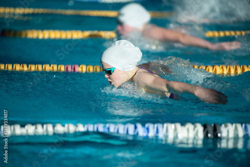 Race of butterfly girls swimmers in the pool