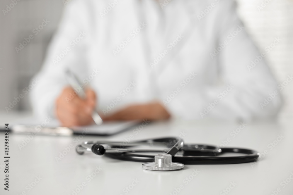 Fototapeta premium Doctor working and stethoscope on table in hospital, selective focus