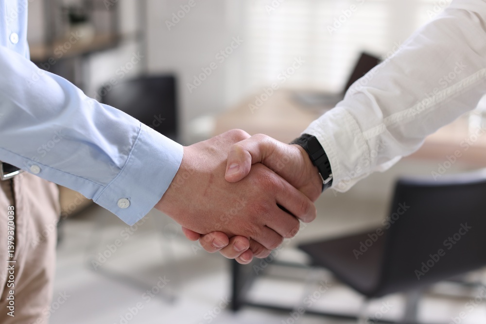 Men shaking hands in agreement indoors, closeup Men shaking hands in agreement indoors, closeup