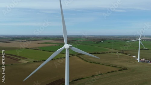 Aerial drone close up view of Wind farm turbines array rural England clean energy renewable generation power plant fossil fuels photo