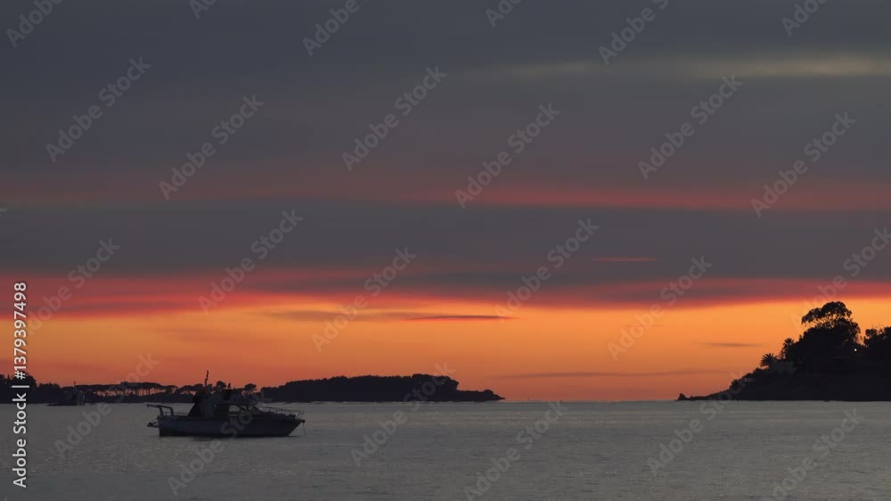 View of a boat floating alone on the sea at sunset View of a boat floating alone on the sea at sunset