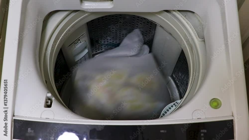 洗濯機の蓋を開けて洗濯物を放り込む 洗濯機の蓋を開けて洗濯物を放り込む
