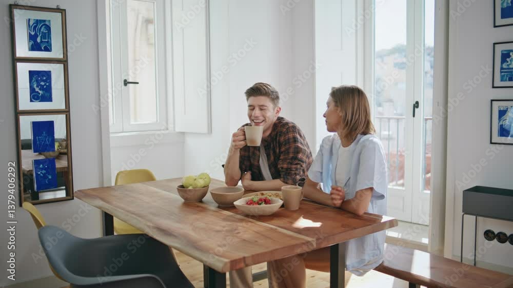 Laughing couple resting home enjoying breakfast. Carefree young people talking Laughing couple resting home enjoying breakfast. Carefree young people talking