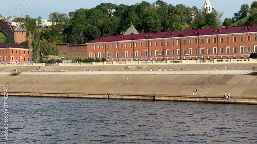 A river with a city in the background. The city is made up of many buildings. The buildings are red and brown