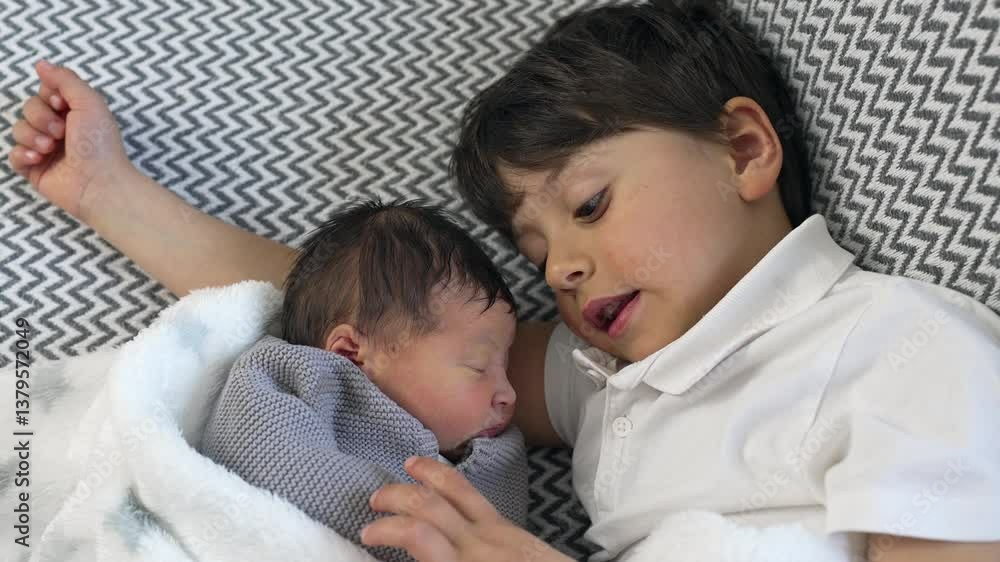 Young boy lays beside his newborn sibling, both wrapped in a soft blanket, capturing a serene and intimate moment of brotherly love and familial bond Young boy lays beside his newborn sibling, both wrapped in a soft blanket, capturing a serene and intimate moment of brotherly love and familial bond