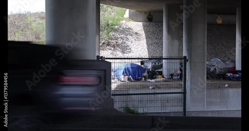 Compton, California, USA - April 2, 2025: A homeless encampment occupies a space below the 91 Freeway.