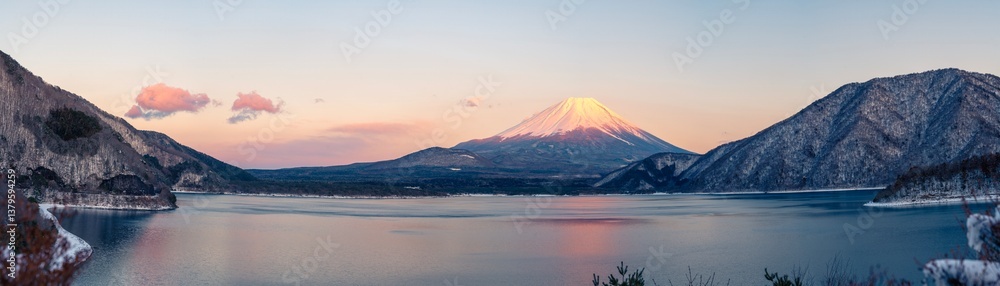 A breathtaking panoramic view of Mount Fuji glowing in the warm light of sunset, captured from the tranquil shores of Lake Motosu, one of the Fuji Five Lakes in Japan. A breathtaking panoramic view of Mount Fuji glowing in the warm light of sunset, captured from the tranquil shores of Lake Motosu, one of the Fuji Five Lakes in Japan.