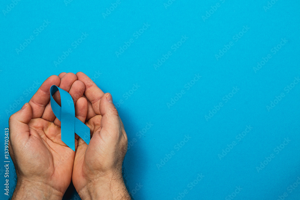Support for cancer awareness through symbolism of blue ribbon in hands Support for cancer awareness through symbolism of blue ribbon in hands