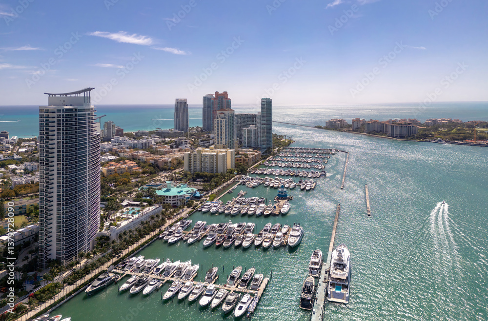 Obraz premium Luxury yacht cruising on Miamis coastline. Aerial view of yachts docked in Miami marina. Miami skyline yachts. Miami Beach with yacht in bay. Summer vacation in Miami. Yachts in South Pointe Marina.