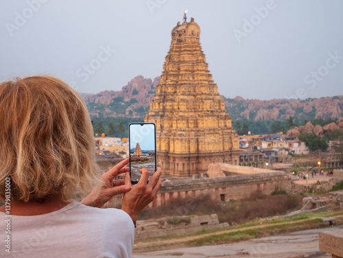 Canvas Print Woman taking photo of amazing temples at Hampi, world famous unesco site
