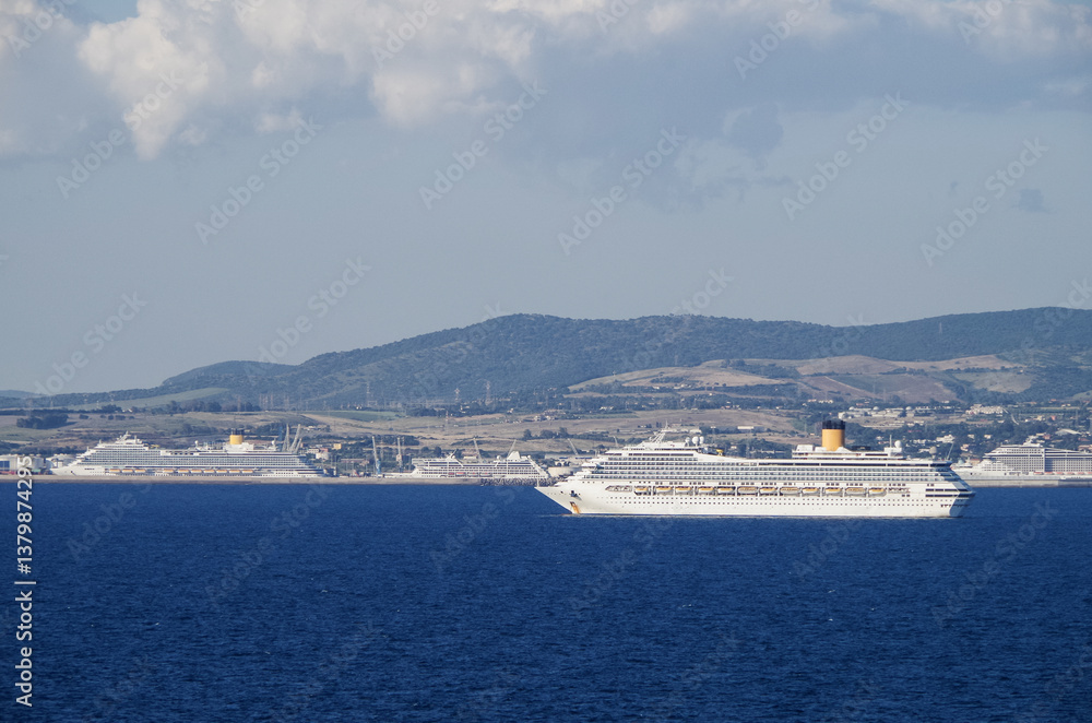 Mega family cruiseship cruise ship liner Fortuna anchored offshore of Civitavecchia Rome, Italy before reactived after Covid pandemic with other vessels in port and coastline
