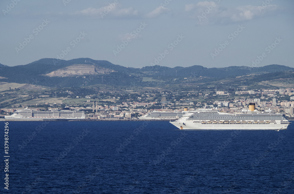 Mega family cruiseship cruise ship liner Fortuna anchored offshore of Civitavecchia Rome, Italy before reactived after Covid pandemic with other vessels in port and coastline