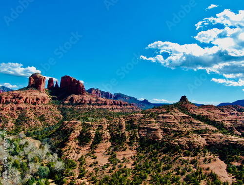 Aerial landscape of Cathedral Rock in Sedona, Arizona with red sandstone formations, desert terrain, and blue sky in Coconino National Forest