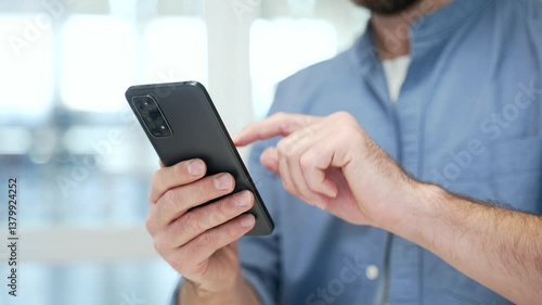 Close up of male hands holding mobile phone at workplace in modern business office. Businessmen using working on application, typing message, chatting, banking or swiping browsing online on smartphone