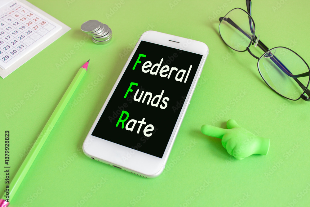 FEDERAL FUNDS RATE symbol. Concept words FEDERAL FUNDS RATE written on the mobile phone screen. Beautiful green background. Glasses, coins. Business concept.