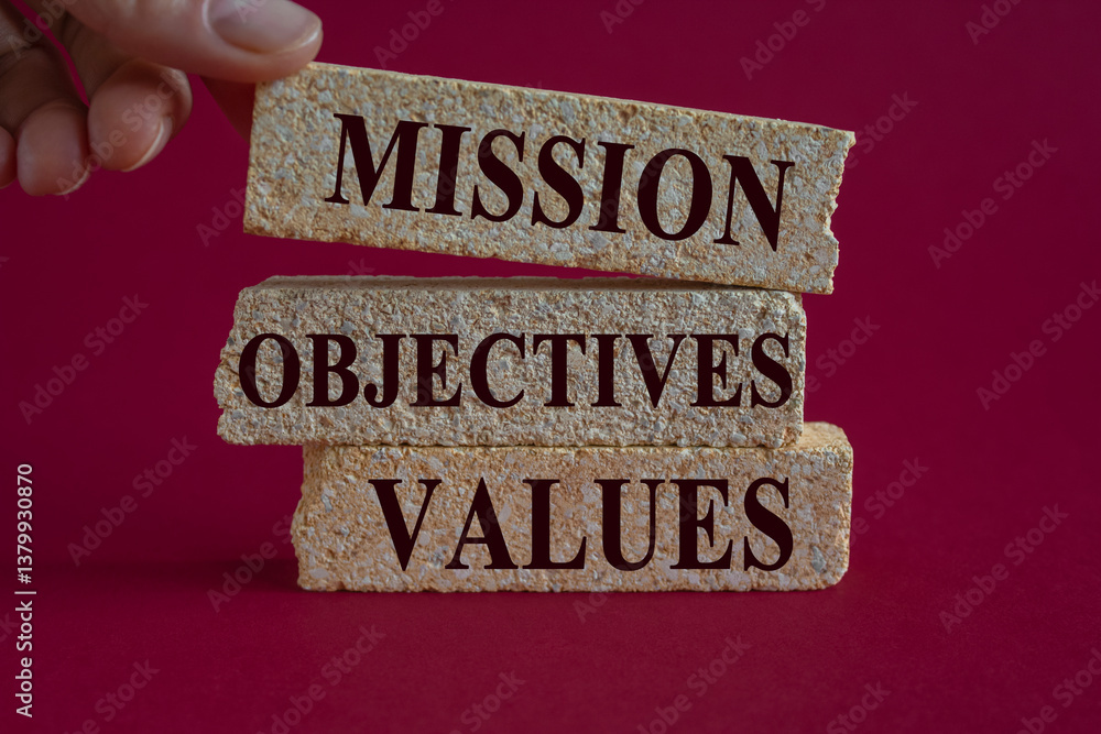 Mission objectives values symbol. Concept words Mission Objectives Values on brick blocks. Beautiful red background. Businessman hand. Business mission objectives values concept.