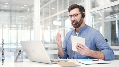Wallpaper Mural Smiling businessman in a headset talking on a video call conference using a laptop sitting at workplace in modern office. Entrepreneur has a business meeting. Coach speaks remotely at an online course Torontodigital.ca