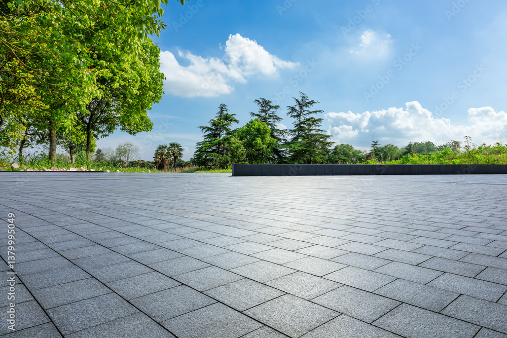 Empty square floor and green trees under a sunny blue sky