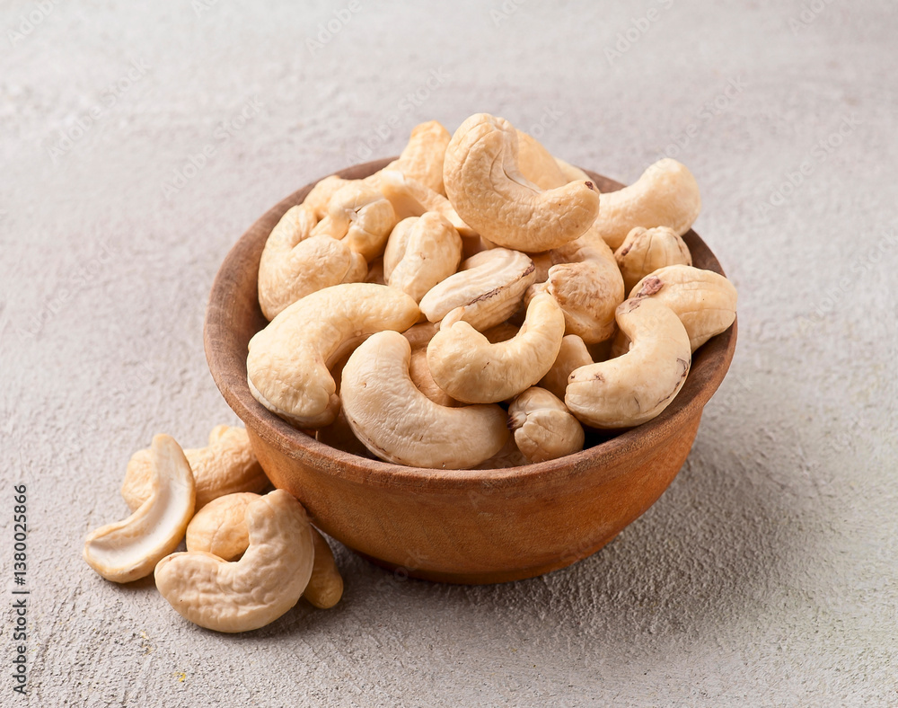 Fototapeta premium Cashew nuts heap with leaves on concrete backgrounds