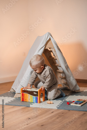 Obraz na płótnie A cheerful child happily plays with a colorful musical toy in a cozy tent, sparking curiosity and creating a delightful experience, while a caring parent watches with love and support w salonie
