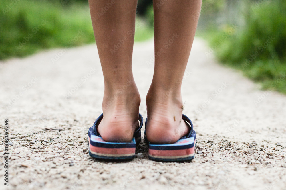 Rear view close-up of a boy's dirty feet wearing flip flops Rear view close-up of a boy's dirty feet wearing flip flops