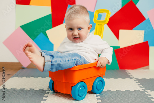 A cheerful toddler plays with a colorful toy cart, immersed in an imaginative world against a lively backdrop, capturing the essence of childhood playfulness during these early life moments