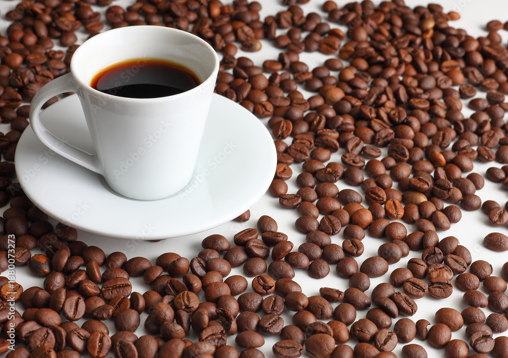 Obraz premium Hot Coffee Cup Surrounded by Roasted Brown Beans on a White Backdrop