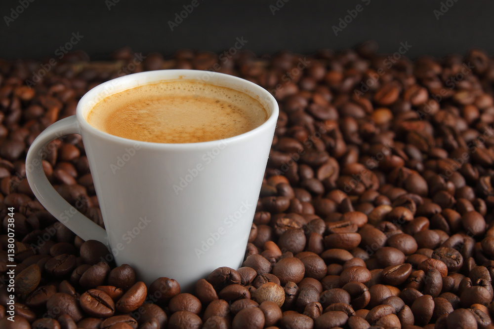 Coffee Beans Surrounding an Espresso coffee in a White Cup on a Dark Background Coffee Beans Surrounding an Espresso coffee in a White Cup on a Dark Background