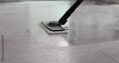 Wallpaper Mural Housewife holds handle of steam mop and cleans tiled floor. Housekeeper moves steam mop back and forth to remove grease spots. Slow motion Torontodigital.ca