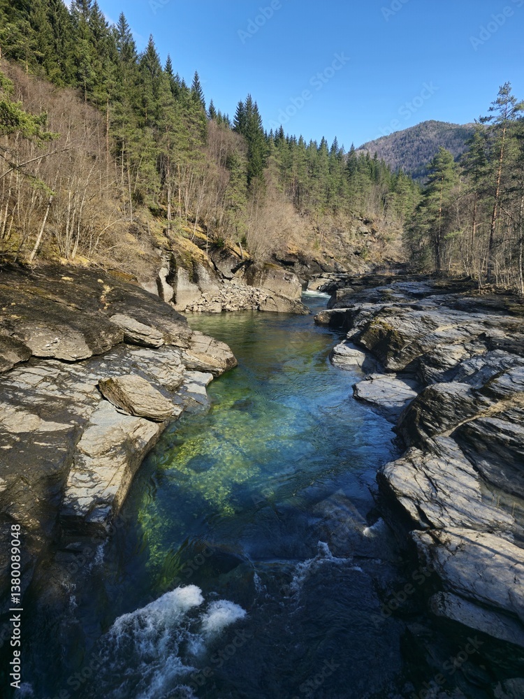 Obraz premium Rapid flow of a waterfall in a rocky area in the forest, Voss, Norway