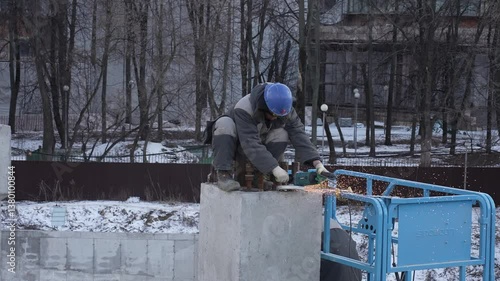 A Construction Worker is Welding at a busy Construction Site today