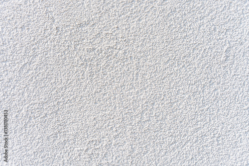 White stucco wall texture under natural light, offering clean background surface ideal for design, construction or architectural presentations