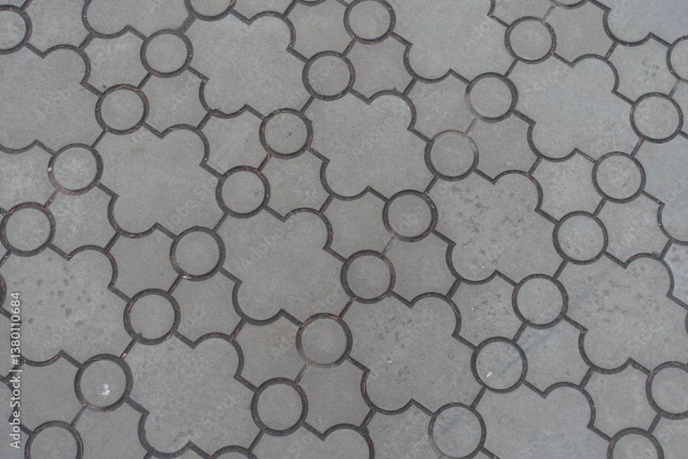 Background - pavement of curved gray interlocking concrete tiles