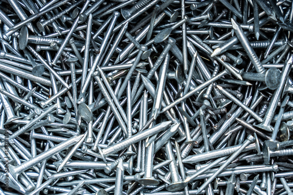 Metallic nails scattered in a dense pile, construction supplies concept with shiny silver surfaces and pointed textures Metallic nails scattered in a dense pile, construction supplies concept with shiny silver surfaces and pointed textures