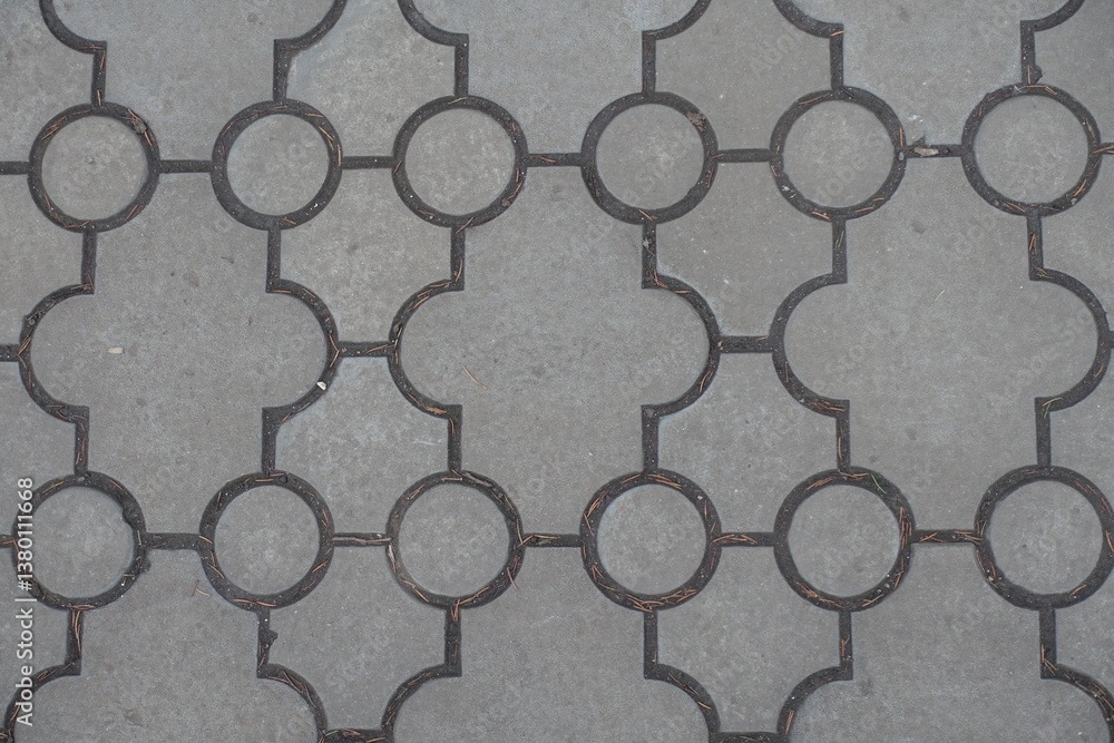 Closeup of pavement of curved gray interlocking concrete tiles