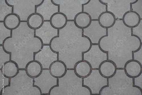 Closeup of pavement of curved gray interlocking concrete tiles