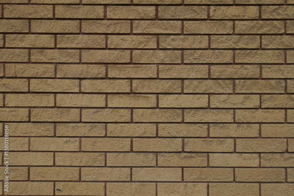 Fototapeta premium Dusty surface of beige split face brick veneer wall with running bond layout