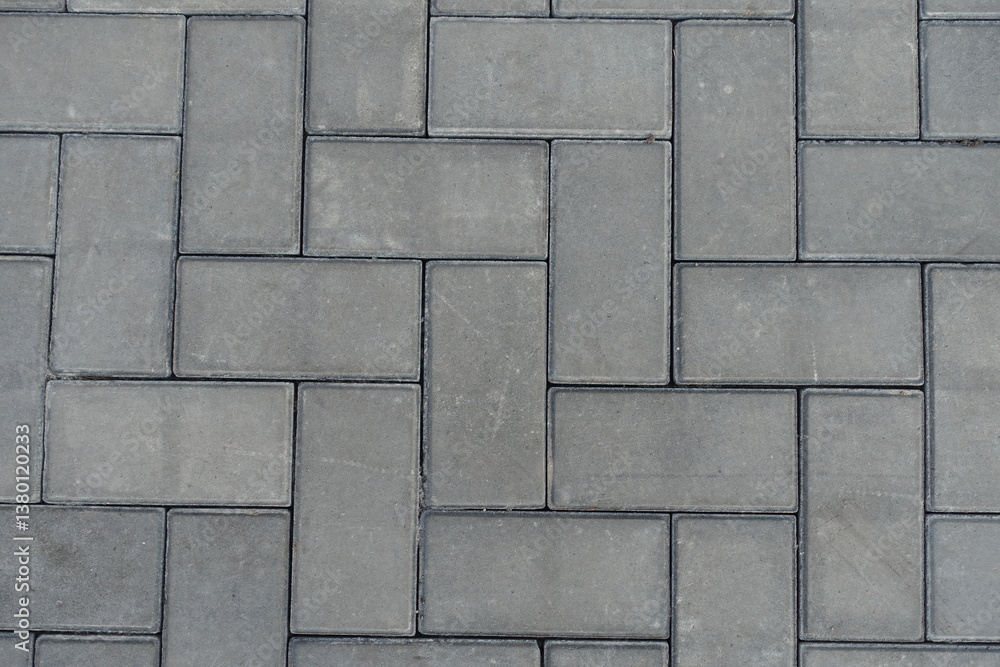 Close shot of grey concrete pavement with single herringbone layout