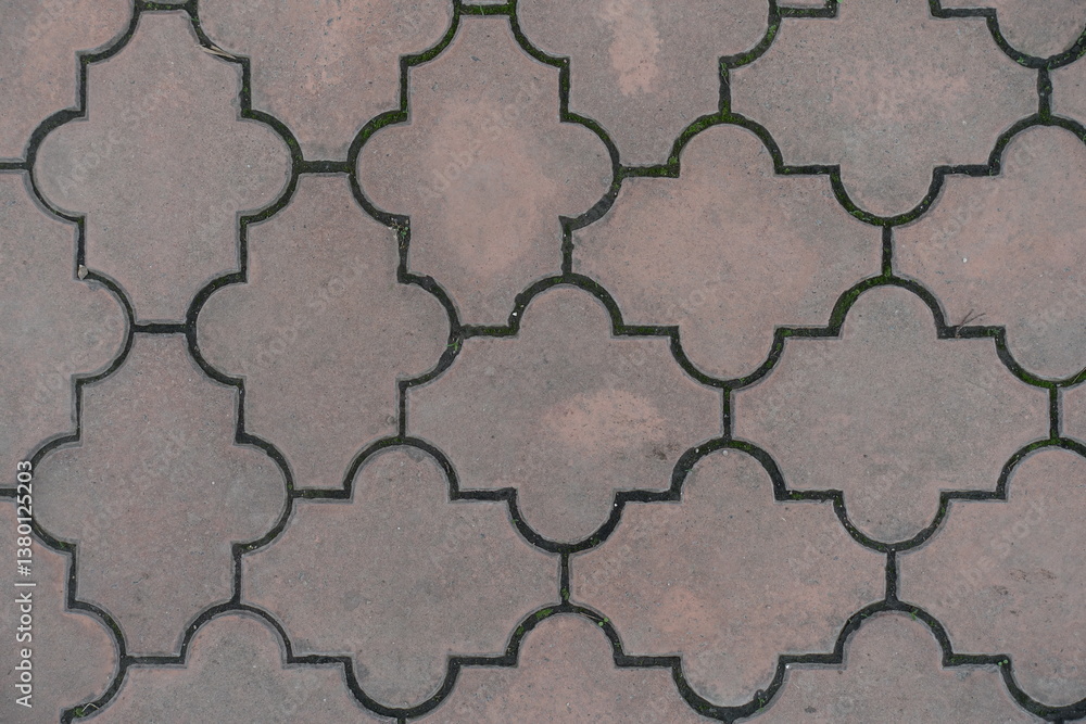 Close shot of pale pink pavement of interlocking concrete tiles with moroccan lattice layout