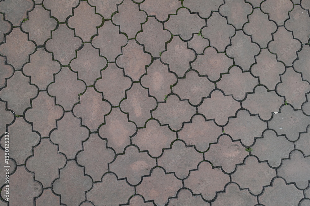 Background - pale pink pavement of interlocking concrete tiles with moroccan lattice layout