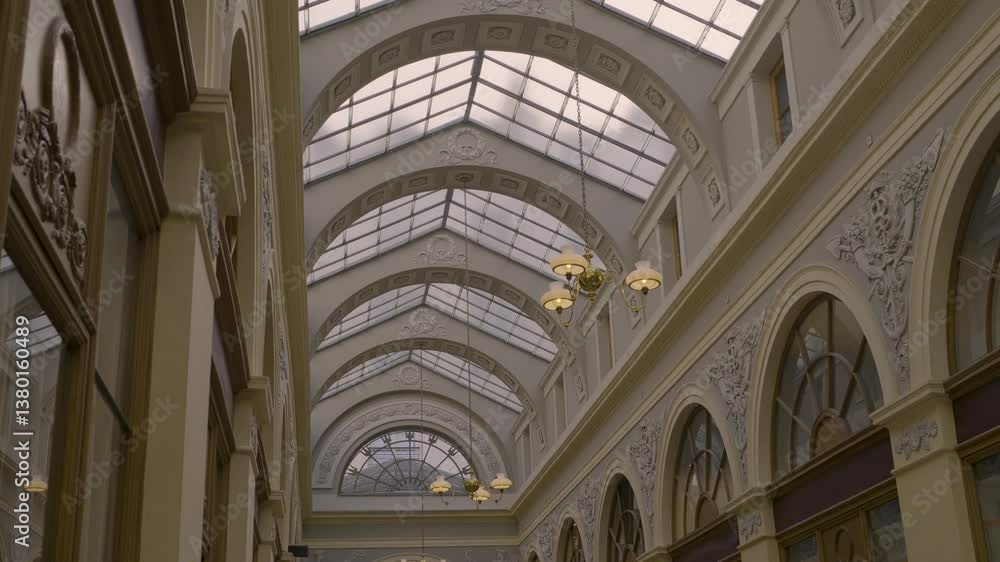Classic Parisian glass-covered arcade with elegant architectural details and lighting Classic Parisian glass-covered arcade with elegant architectural details and lighting