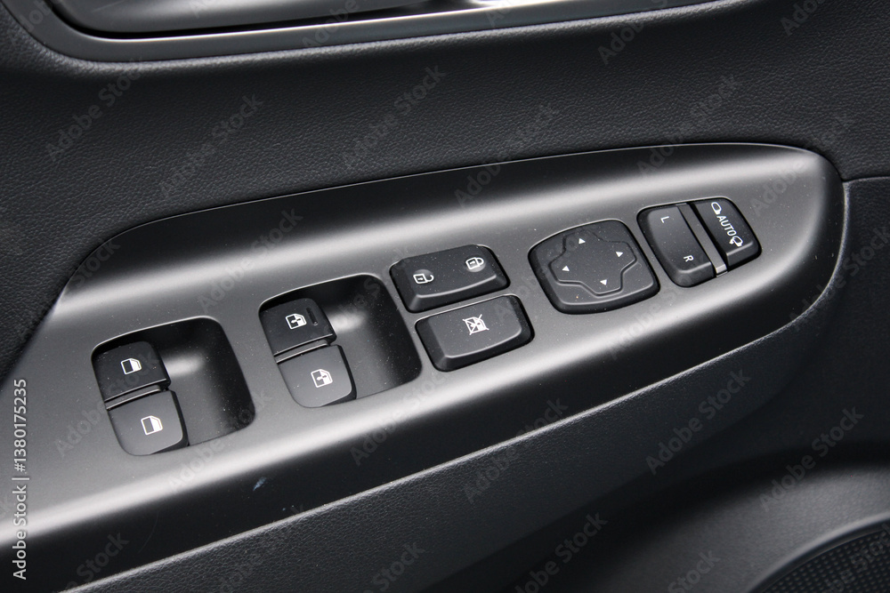 Window control buttons in modern electric car. Car leather interior details of door handle with windows controls and adjustments. Door trim. Modern car interior details. Window control buttons in modern electric car. Car leather interior details of door handle with windows controls and adjustments. Door trim. Modern car interior details.