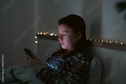 Obraz na płótnie Girl using smart phone while lying on bed in bedroom w salonie