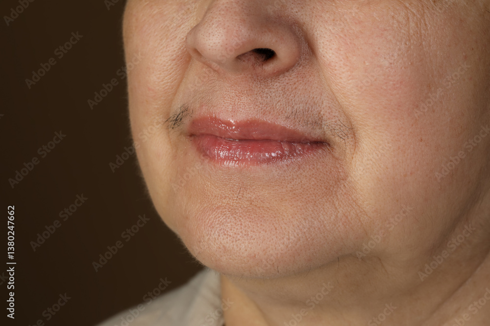 Fototapeta premium Senior woman with mustache on brown background, closeup