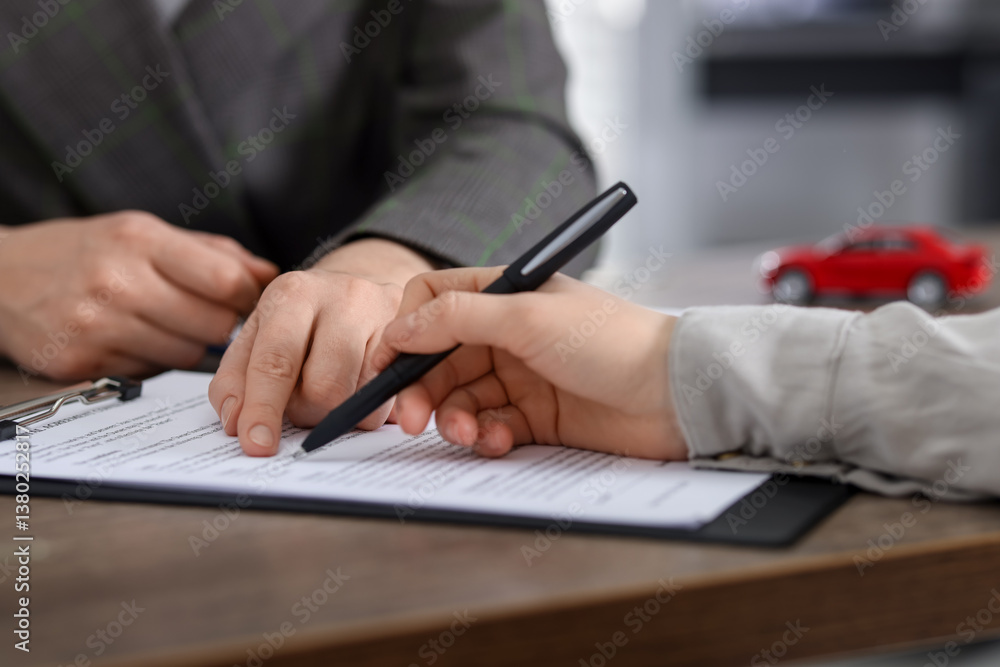 Manager and client signing car purchase agreement at wooden table, selective focus. Buying auto Manager and client signing car purchase agreement at wooden table, selective focus. Buying auto