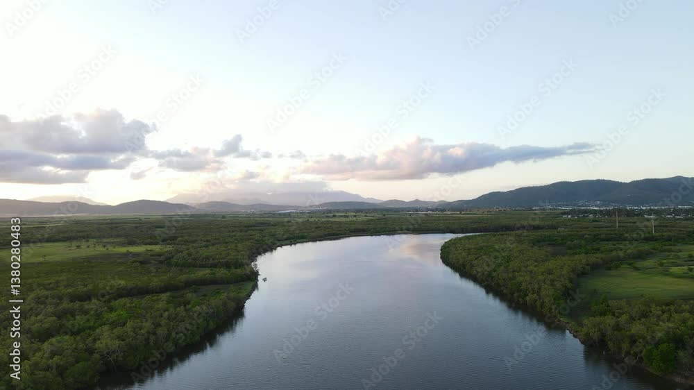 Crocodile inhabited Ross River with a distant view of Mount Stuart, Townsville Queensland Australian. Drone aerial view Crocodile inhabited Ross River with a distant view of Mount Stuart, Townsville Queensland Australian. Drone aerial view