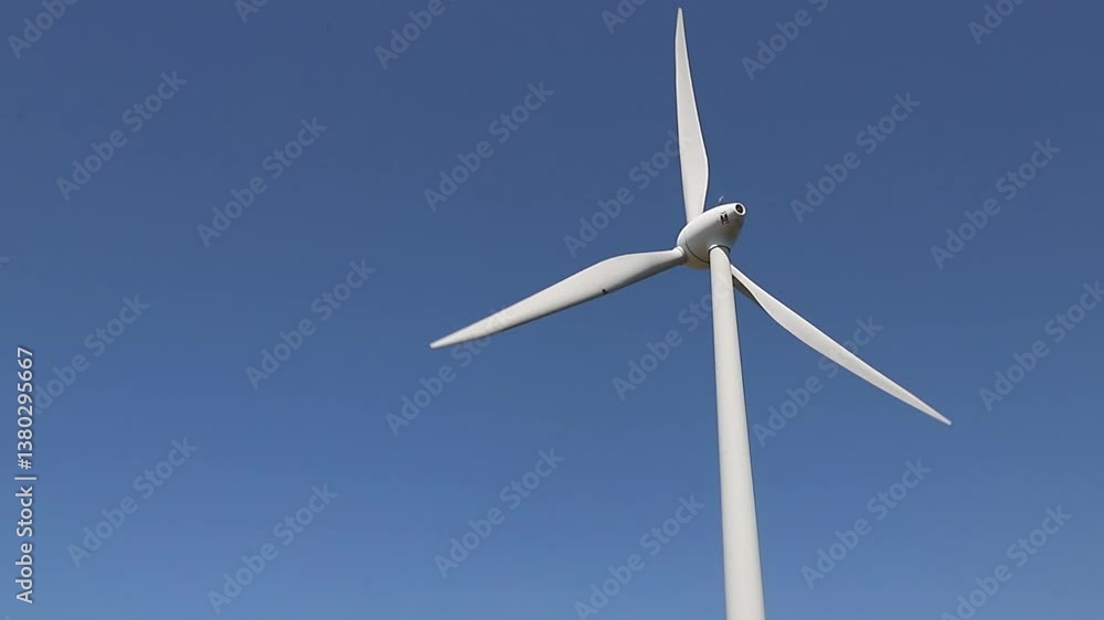 Wind turbine spinning against a clear blue sky Wind turbine spinning against a clear blue sky