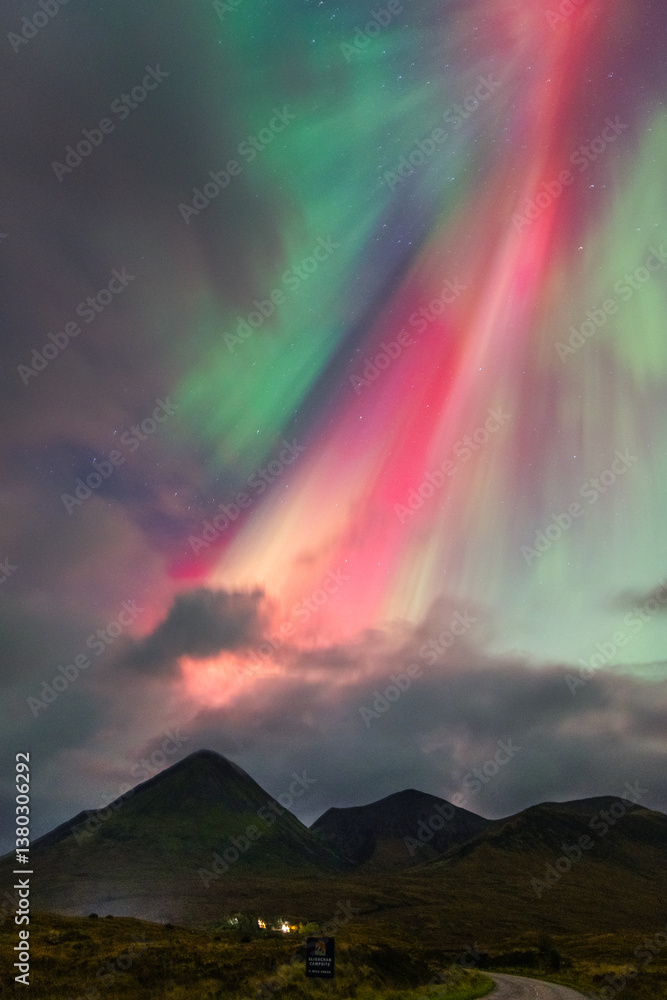 The Northern Lights dance over the Isle of Skye, painting the night sky in vibrant greens and purples. A magical display above Scotland’s rugged landscapes.
