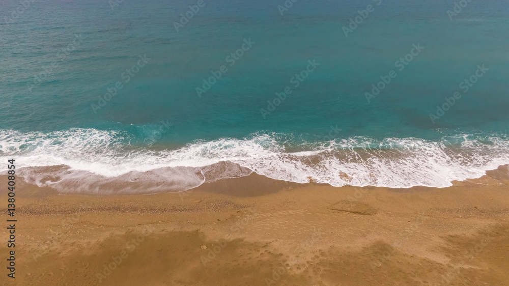 Sunny golden sandy beach. Panoramic view of calm sandy beach. Peaceful waves on the seashore. Ocean shore view. Aerial photography beachside. Seaside, exotic, tropical, Mediterranean nature landscape.